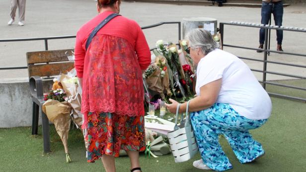 Frauen legen nach Messerattacke auf Kinder in Frankreich Blumen nieder.