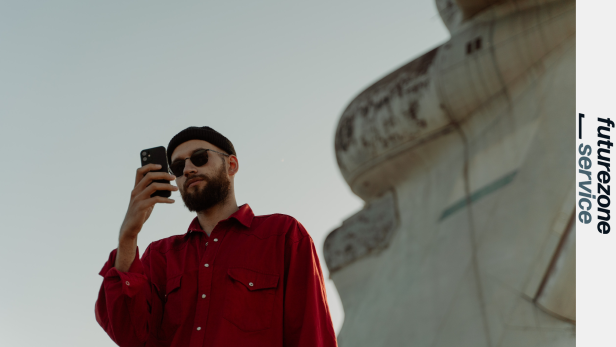 Ein Mann mit Bart und Sonnenbrille macht ein Foto mit seinem Smartphone.
