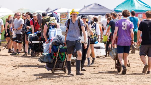 Besucher des Nova Rock Festivals 2023 transportieren ihr Gepäck.