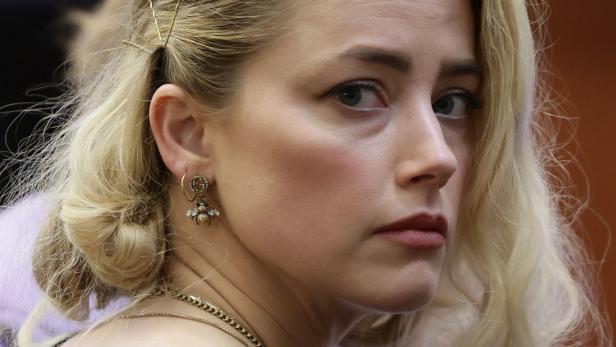 Nahaufnahme von Amber Heard mit blonden Haaren und Bienenohrringen.