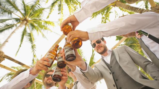 Party am Strand und Männer mit Bier.