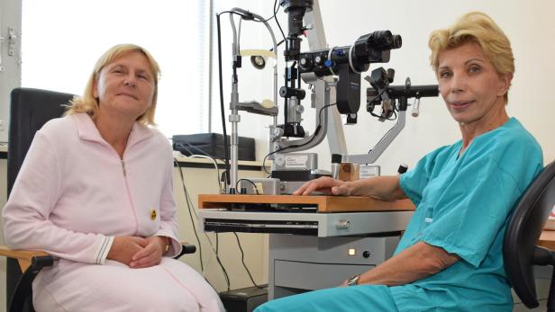 Eine Ärztin untersucht die Augen einer Patientin mit einem medizinischen Gerät.