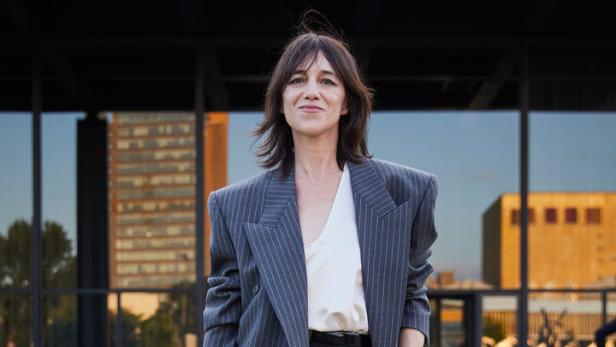 Charlotte Gainsbourg trägt einen Blazer und einen Rock mit Nadelstreifen.