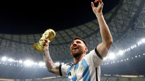 FILE PHOTO: Argentina's Lionel Messi celebrates winning the World Cup with the trophy, Lusail, Qatar - December 18, 2022