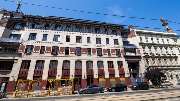 Ein mehrstöckiges Gebäude mit Jugendstil-Elementen in einer städtischen Umgebung.