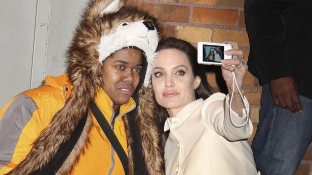 Angelina Jolie macht ein Selfie mit einem Fan mit Wolfsmütze.