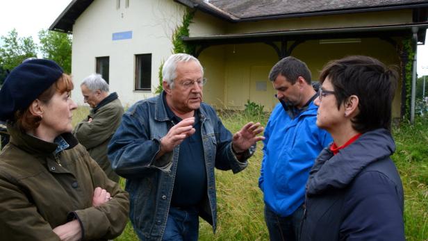 Eine Gruppe von Menschen steht vor einem Gebäude mit der Aufschrift „Thuya“.