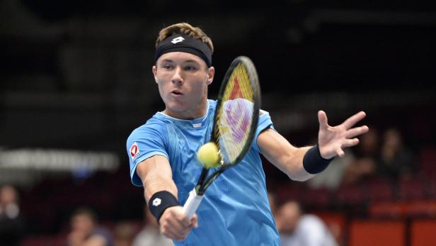 Ein Tennisspieler schlägt einen Ball mit seinem Schläger.