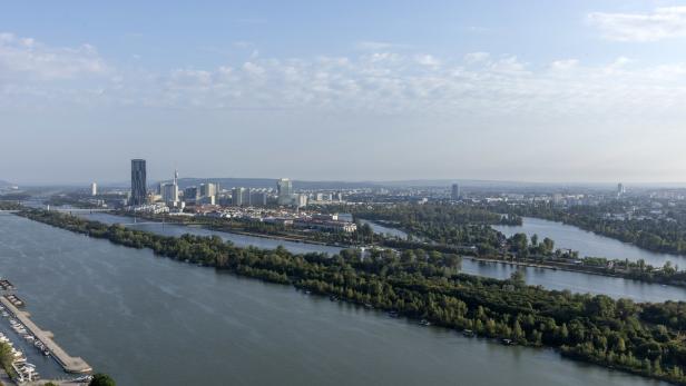 Luftaufnahme von Wien mit der Donau und der Donau City im Hintergrund.