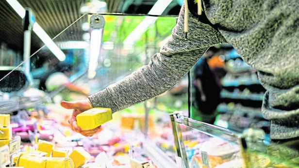 close up person hand buying cheese in  store