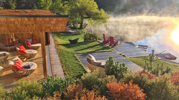 Ein Resort am See mit Nebel über dem Wasser bei Sonnenaufgang.