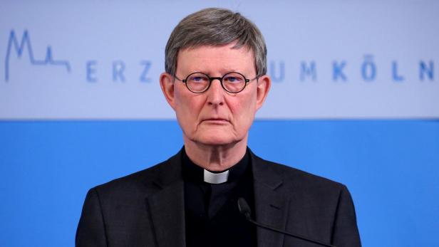 Porträt von Rainer Maria Kardinal Woelki vor einem blauen Hintergrund.