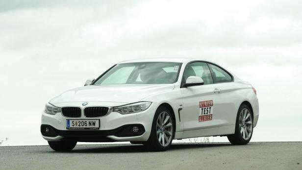 Ein weißer BMW steht auf einer Straße.