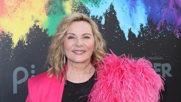 Kim Cattrall trägt einen pinkfarbenen Blazer mit Federn.
