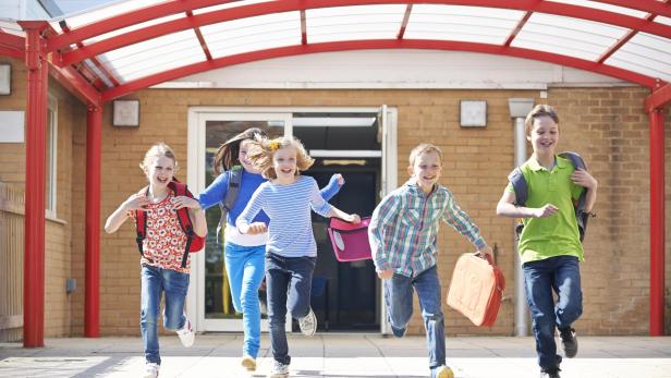 Schoolchildren Running Into Playground At End Of Class