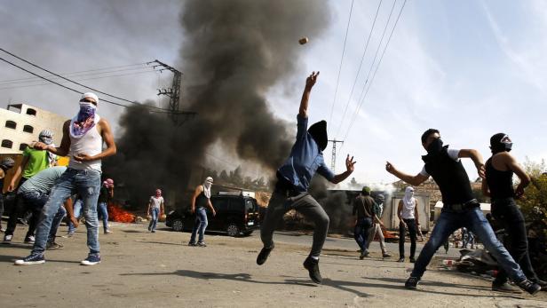 Palästinensische Jugendliche werfen Steine und Molotowcoctails auf israelische Soldaten in Hebron.