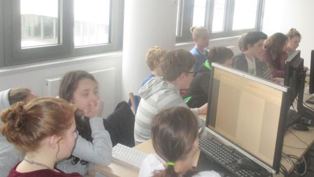 Eine Gruppe von Schülern arbeitet an Computern in einem Klassenzimmer.