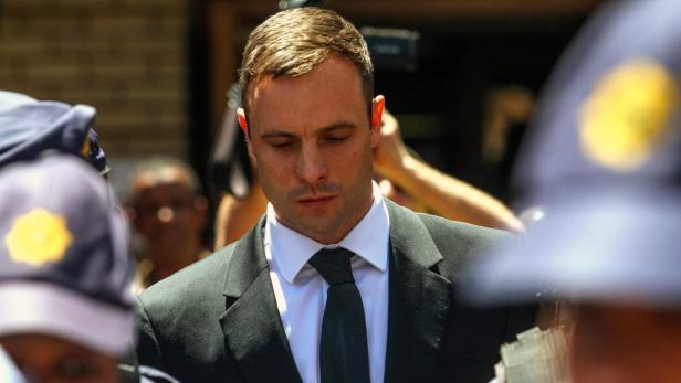 Oscar Pistorius bei einer Gerichtsverhandlung, umgeben von Polizisten.