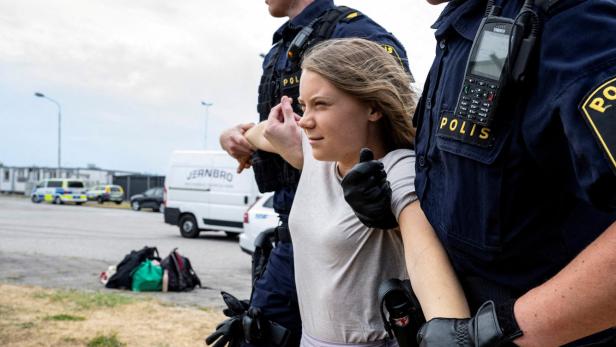 Greta Thunberg wird von zwei Polizisten weggezerrt