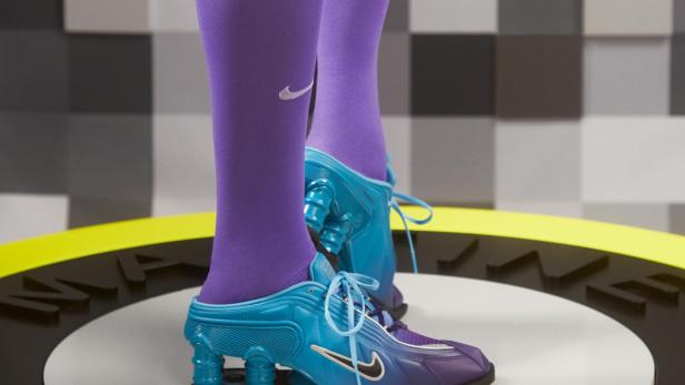 Nahaufnahme von blauen Nike Shox Mule MR4 mit lila Socken.