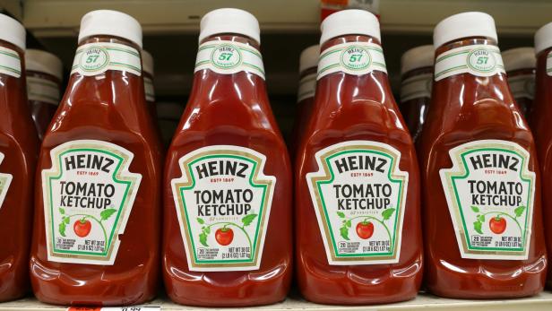 Mehrere Flaschen Heinz Tomatenketchup stehen in einem Regal.