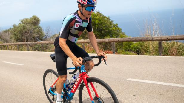 Ein Radfahrer fährt auf einer Küstenstraße mit Blick auf das Meer.