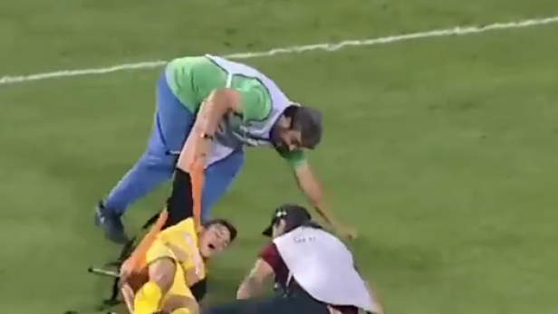 Ein verletzter Fußballspieler wird von Sanitätern auf dem Spielfeld behandelt.