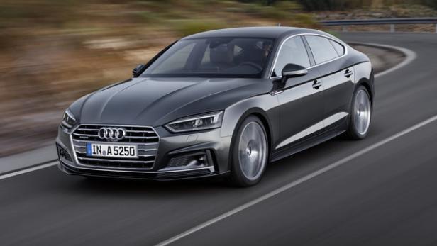 Ein grauer Audi A5 fährt auf einer asphaltierten Straße.