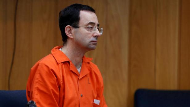 FILE PHOTO: Larry Nassar, a former team USA Gymnastics doctor who pleaded guilty in November 2017 to sexual assault charges, listens to Judge Janice Cunningham during his sentencing hearing in the Eaton County Court in Charlotte