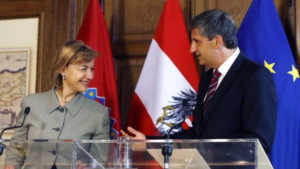 Die Präsidentin von Kroatien trifft sich mit dem Präsidenten von Österreich vor Flaggen.