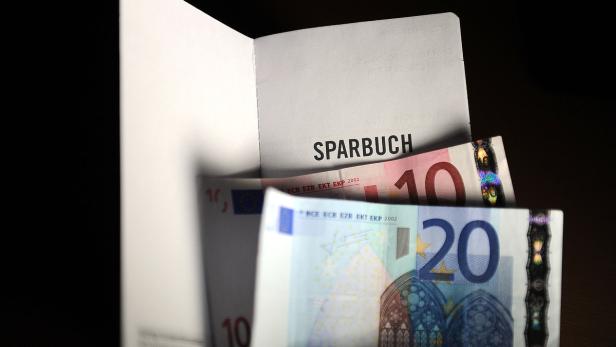 Ein Sparbuch mit einem 10-Euro-Schein und einem 20-Euro-Schein.