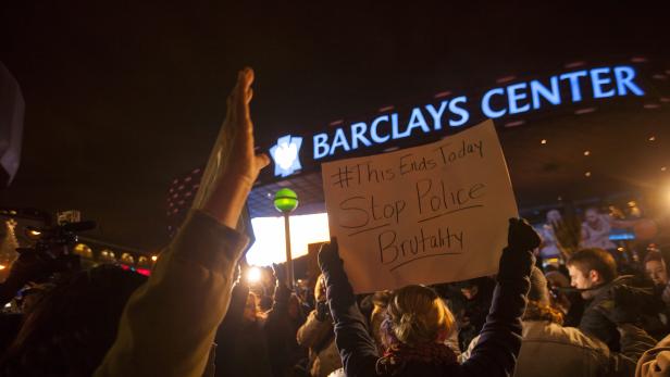 Demonstranten halten Schilder vor dem Barclays Center hoch.