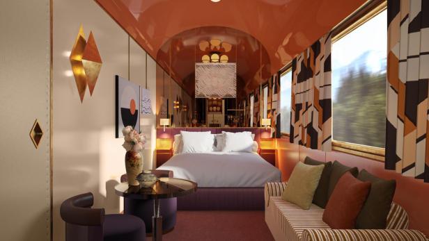 Innenansicht einer luxuriösen Schlafkabine in einem Zug mit Doppelbett und Sitzecke.