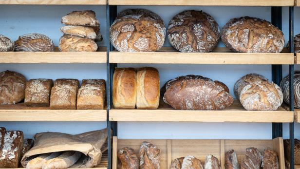 Regale in einer Bäckerei sind mit verschiedenen Brotsorten gefüllt.