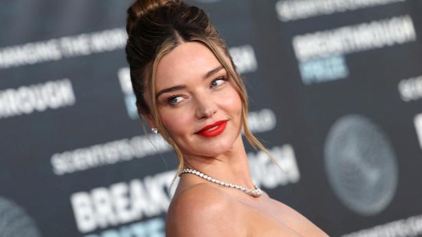Miranda Kerr mit hochgesteckten Haaren und rotem Lippenstift auf dem roten Teppich.
