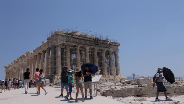 Visitors walk at the Acropolis during a heatwave in Athens