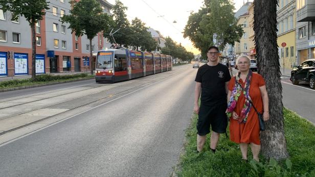 Karin Prauhart und Richard Heuberger von den Grünen Hernals stehen in der Hernalser Hauptstraße während gerade eien 43er durchfährt