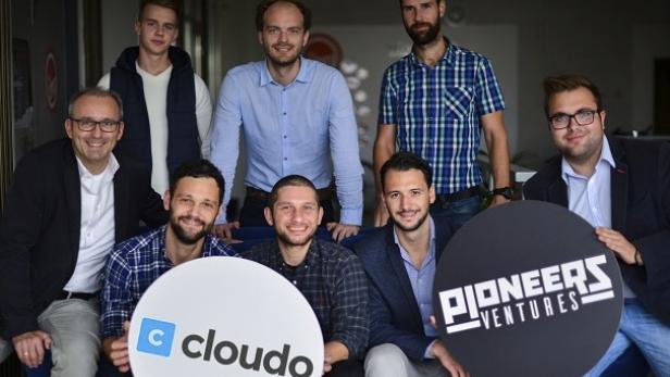 Eine Gruppe von Männern posiert mit den Logos von „Cloudo“ und „Pioneers Ventures“.