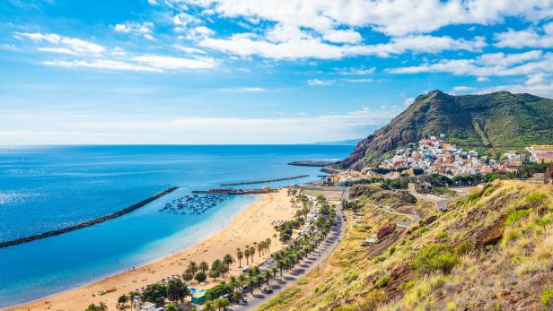 Ein Panoramablick auf den Strand Las Teresitas auf Teneriffa mit einem Berg im Hintergrund.