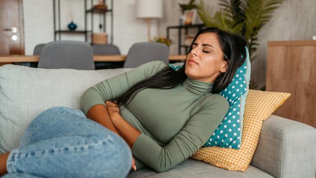 Junge Frau mit Bauchkrämpfen