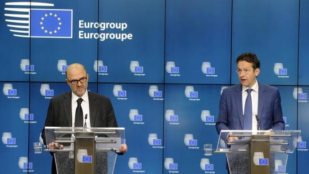 Zwei Männer stehen an Rednerpulten vor einem Hintergrund der Eurogruppe.