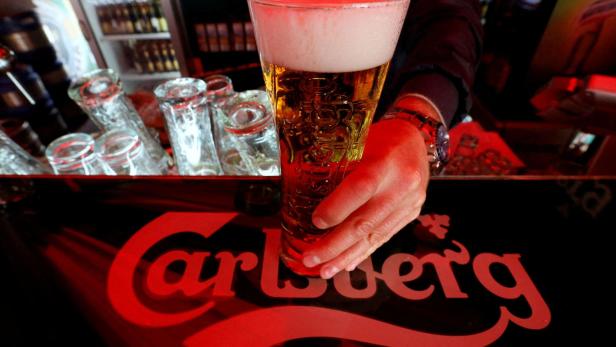 FILE PHOTO: A bartender holds a glass of Carlsberg beer in a bar in St. Petersburg