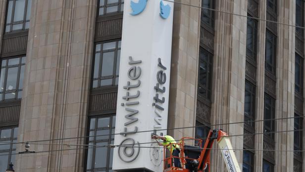 Arbeiter entfernen Buchstaben vom ikonischen vertikalen Twitter-Schild, nachdem Elon Musk es in X umbenannt hat.