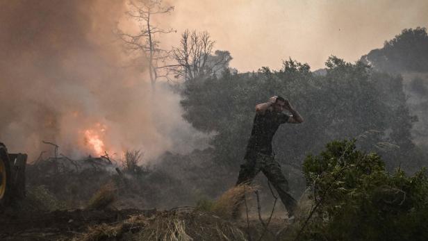 Mann läuft vor Waldbrand in Griechenland davon