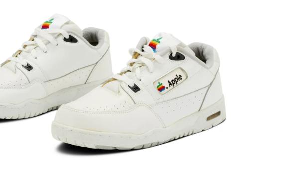 Zwei weiße Sneaker mit dem alten Apple-Logo.