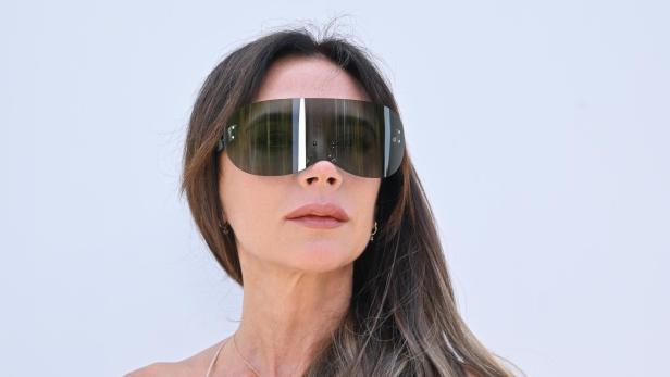 Victoria Beckham trägt eine futuristisch anmutende Sonnenbrille.