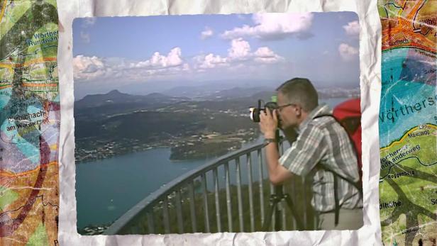 Ein Mann fotografiert die Aussicht vom Pyramidenkogel-Turm am Wörthersee.