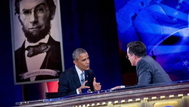 Barack Obama im Gespräch mit Stephen Colbert vor einem Porträt von Abraham Lincoln.
