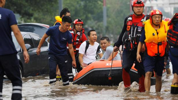Rescue workers evacuate flood-affected residents using a boat in Beijing