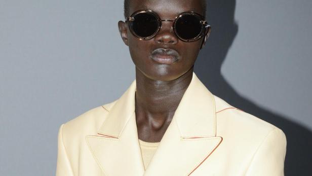 Ein Model mit Sonnenbrille und hellgelbem Blazer von Louis Vuitton.